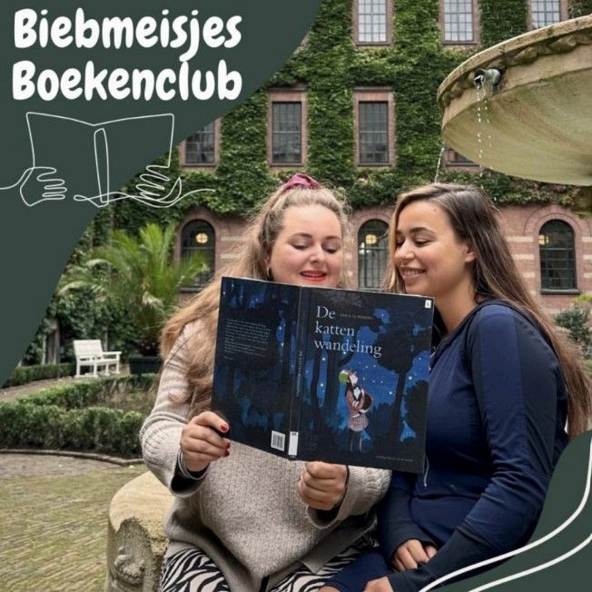 Twee leesconsulenten kijken samen in het boek De kattenwandeling